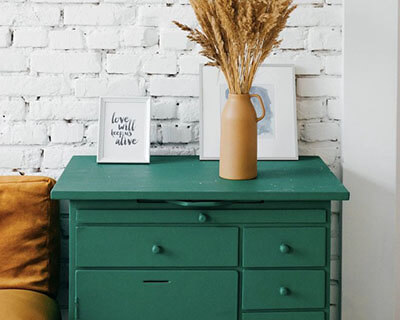 Green cupboards with drawers and plants on top